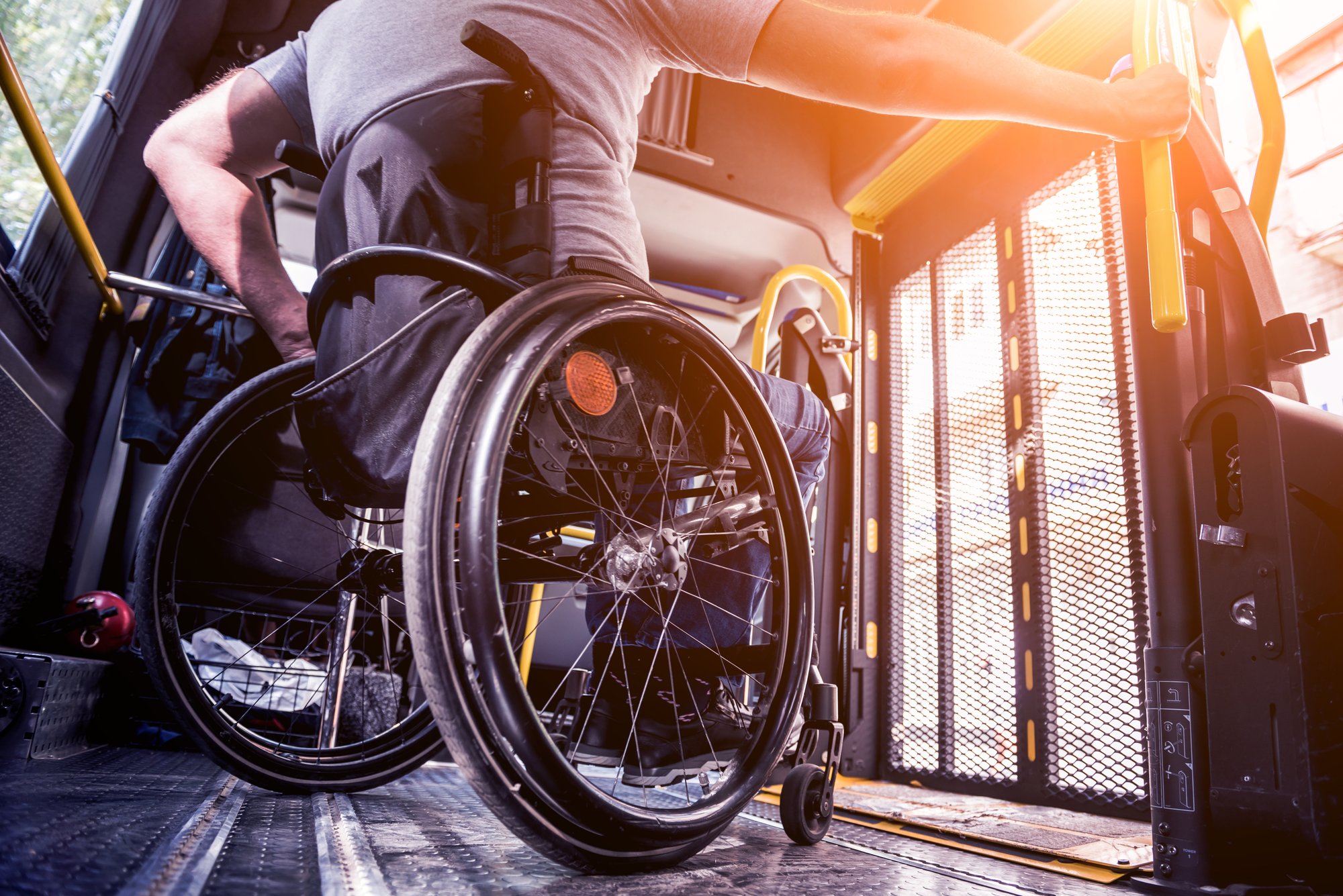 a man in a wheelchair riding a paratransit vehicle.